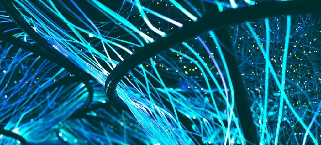 A mesmerizing display of glowing neon blue optical fibers creating a futuristic atmosphere.